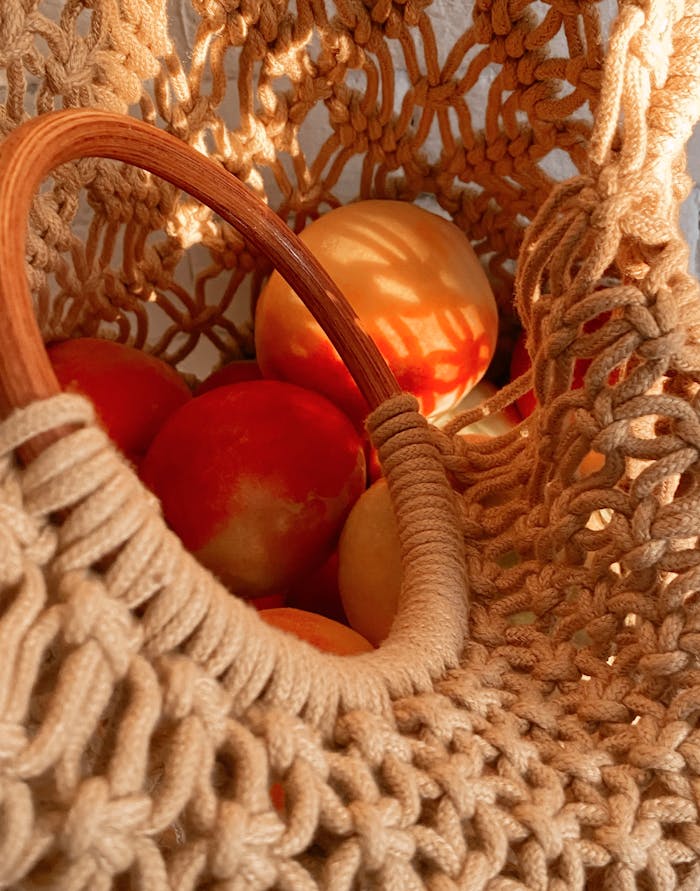 our-services-3 Close-up of a knitted bag filled with ripe peaches, displaying an eco-conscious shopping style.